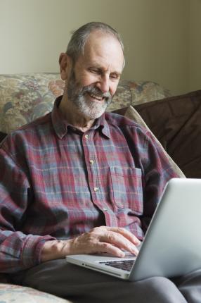 homme assis avec son ordinateur portable ouvert
