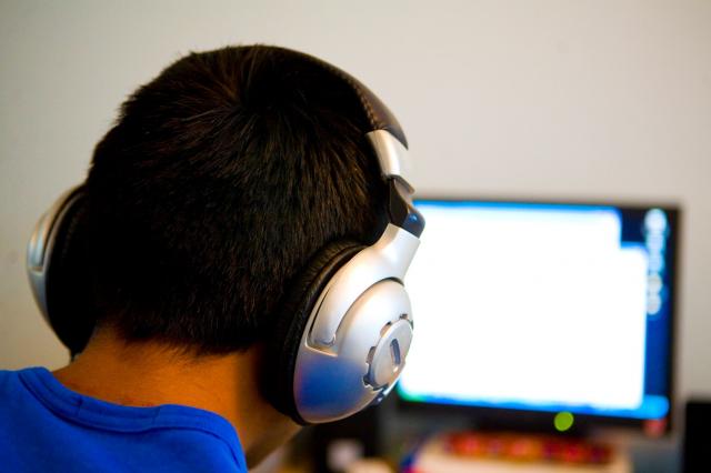 Man using headphones to listen to computer