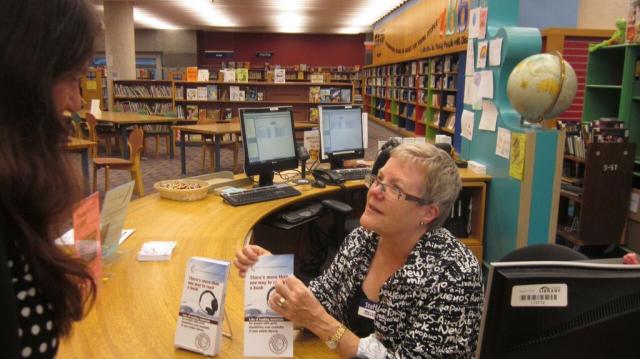 Une bibliothécaire aide un abonné