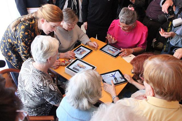 Une femme en aide une autre avec un iPad